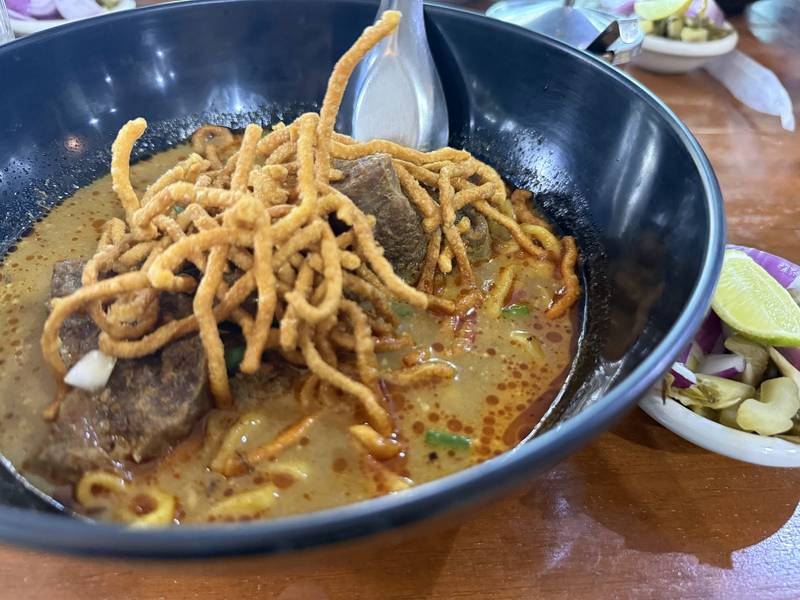 ข้าวซอยเนื้อโรยเส้นกรอบในชามสีน้ำเงิน