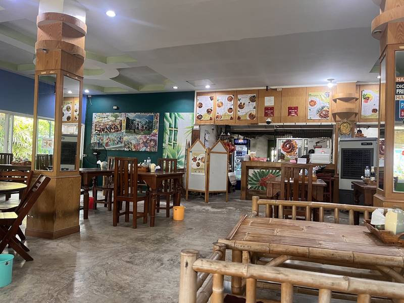 ภายในร้านข้าวซอยไทใหญ่ โต๊ะไม้และม้านั่งไม้ไผ่